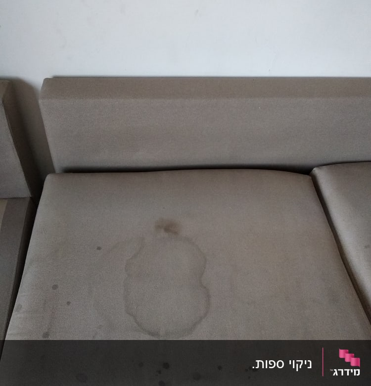 כתמים על ספה אפורה לפני ניקוי